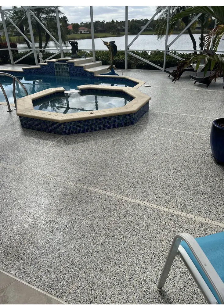Coated gray flake pool deck surrounding a swimming pool and spa
